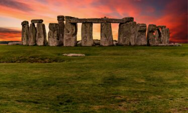 Capture of the iconic Stonehenge during a vibrant sunset with a dramatic sky.