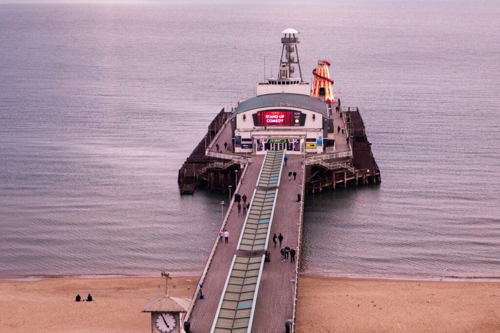 Scenic view of Bournemouth Pier with people against a tranquil sea at dusk.