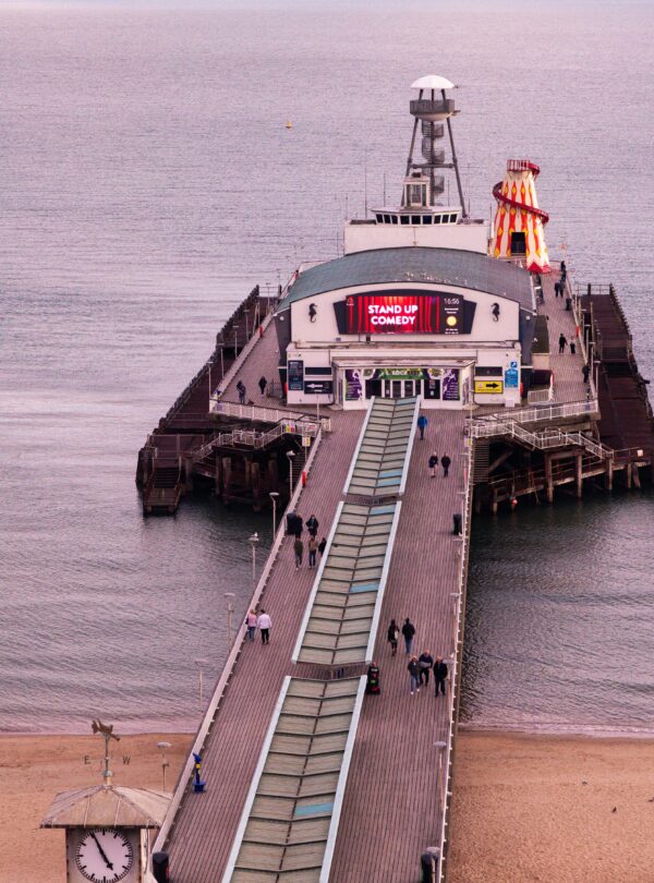Scenic view of Bournemouth Pier with people against a tranquil sea at dusk.